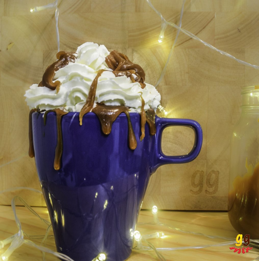a mug of hot chocolate topped with whipped cream and salted caramel